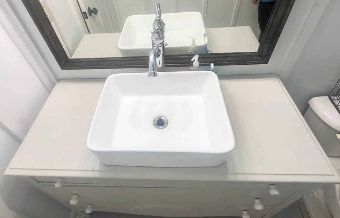 overhead view of vessel sink on top of dresser bathroom vanity.