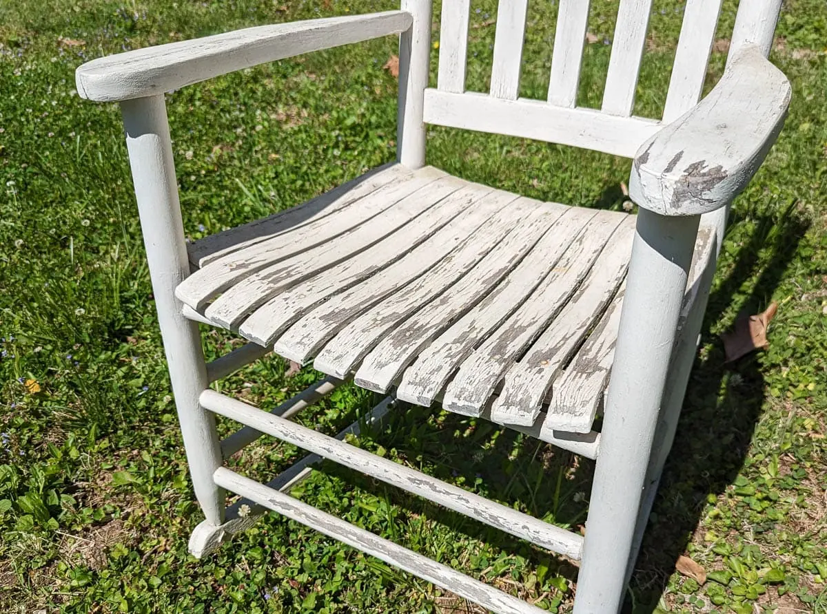 close up of chipping paint on wooden rocking chair.