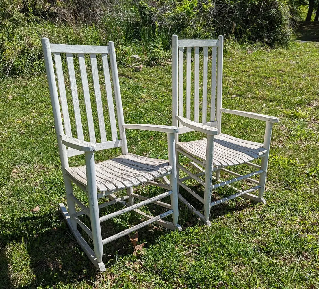 white wood rocking chairs with chipping paint.