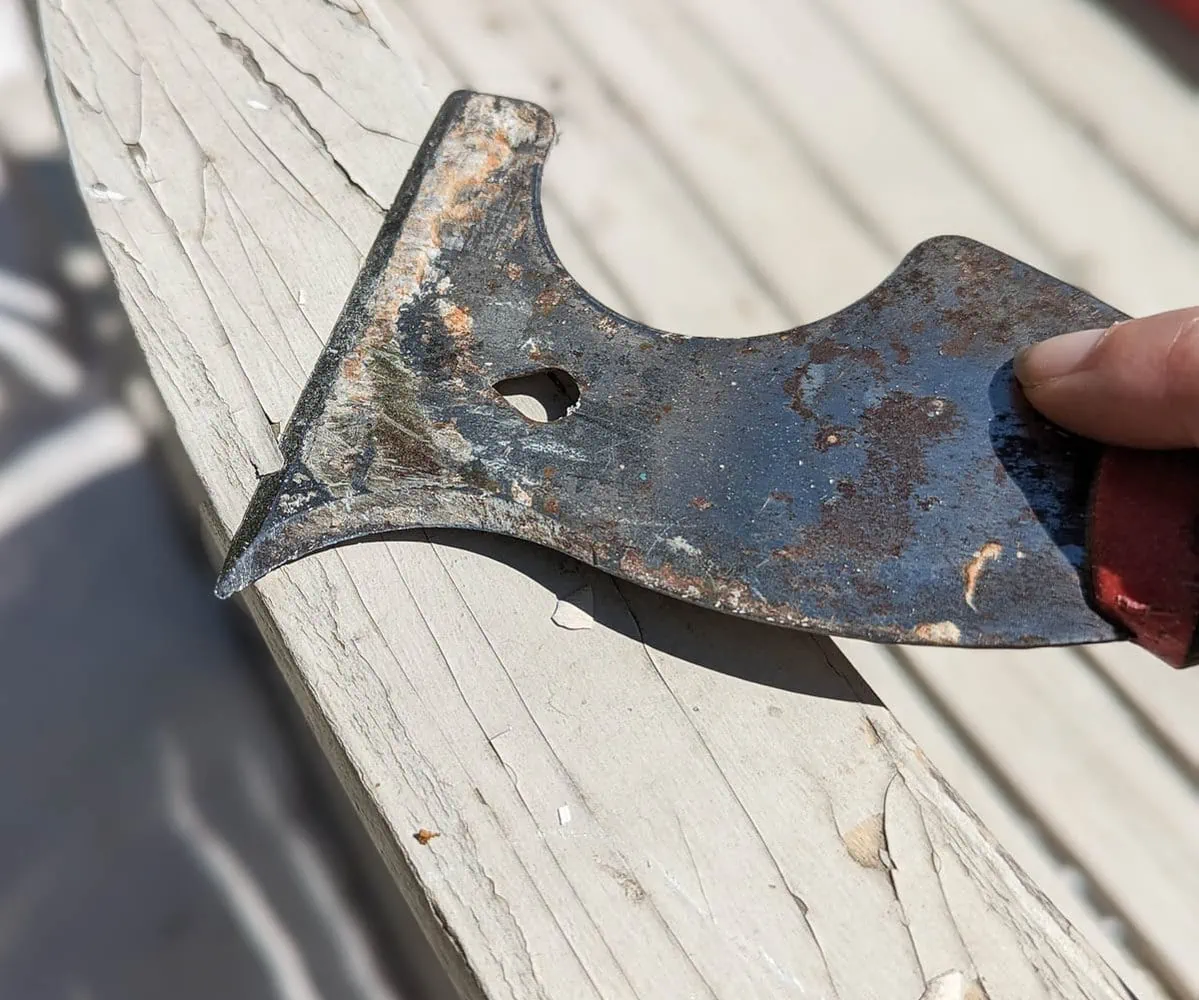 scraping peeling paint with a paint scraper.