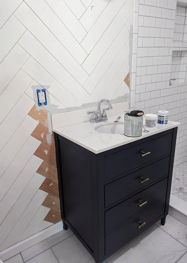 fixing the herringbone wood wall around the new vanity.