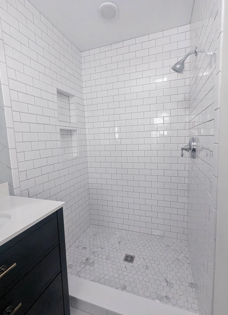 walk-in shower tiled with white subway tile.