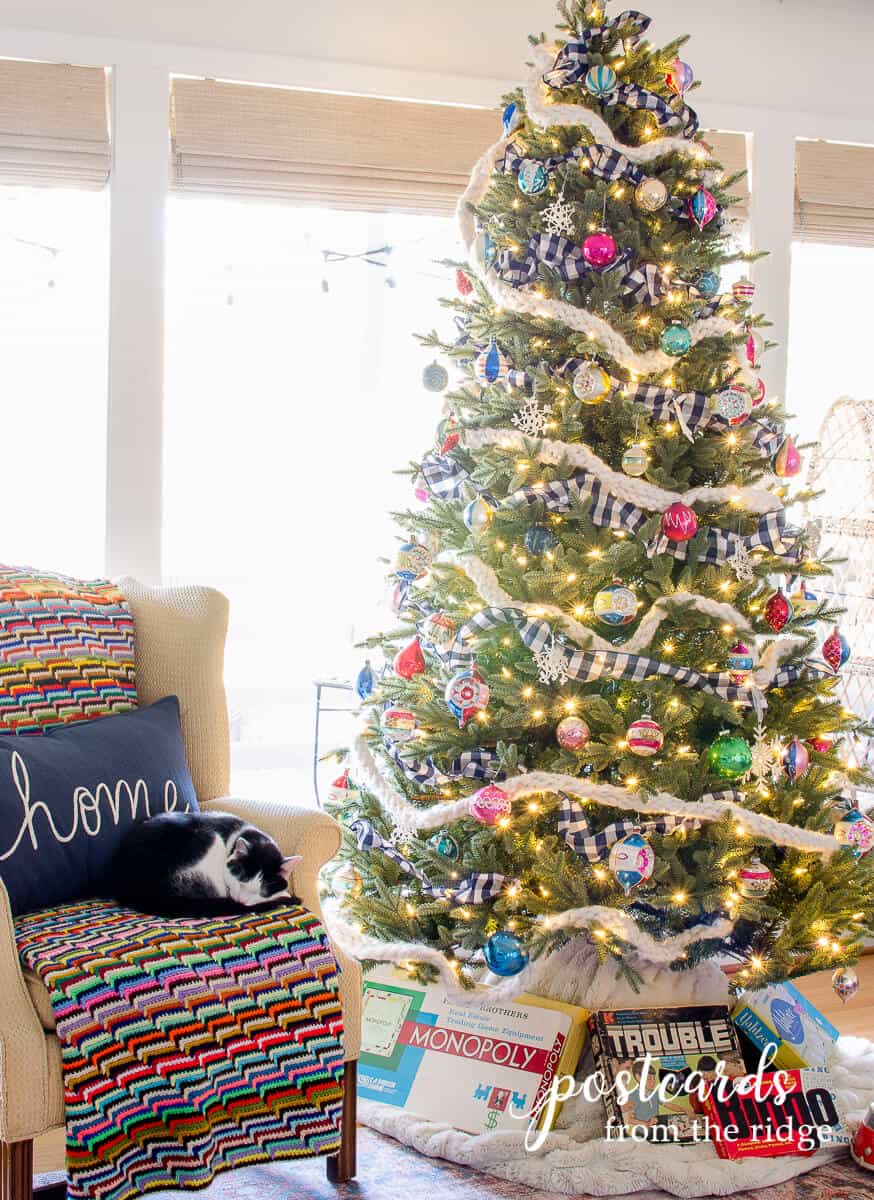 Christmas tree with vintage shiny brite ornaments, a plaid ribbon, and a woven ribbon.