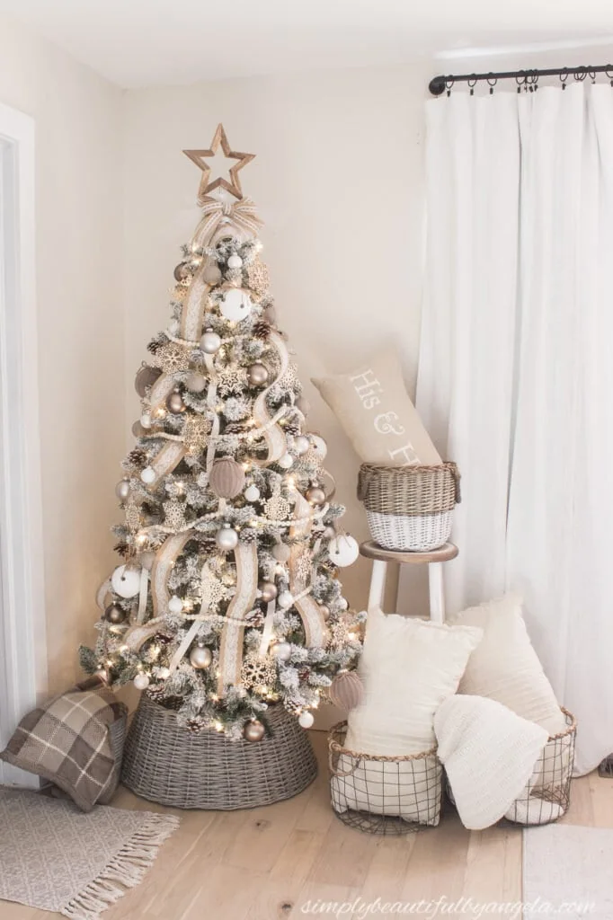 neutral Christmas tree with lace ribbon and wood bead garland and a simple bow on top.