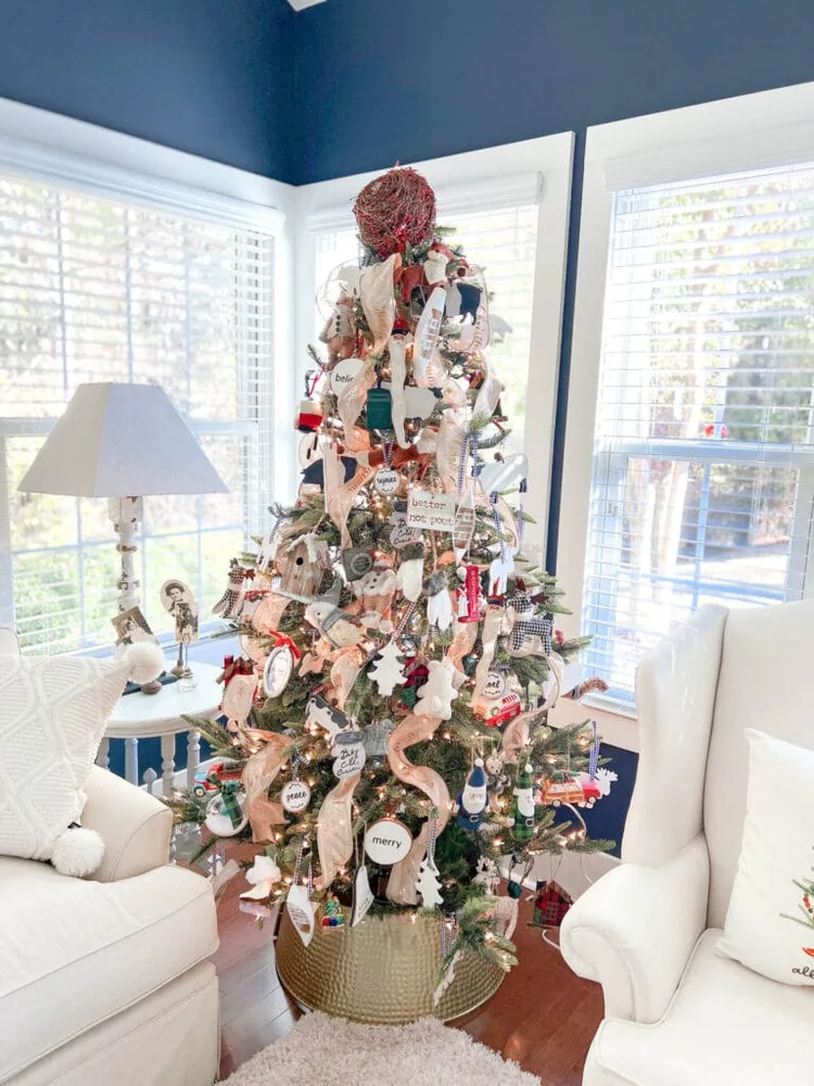 Christmas tree with lots of ornaments and vertical ribbon.