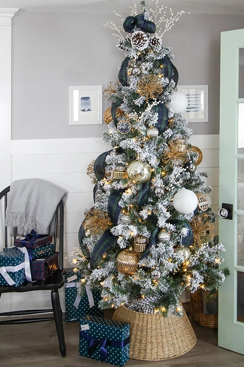 Tree with gold ornaments and navy and green plaid ribbon. 