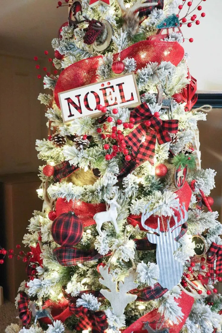 Christmas tree with red, black, and white ornaments, red burlap ribbon, and plaid ribbon.