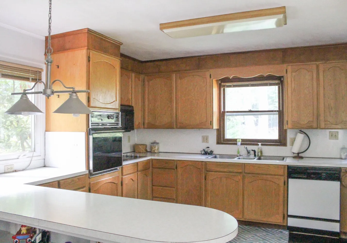 outdated kitchen with oak cabinets and laminate countertops.