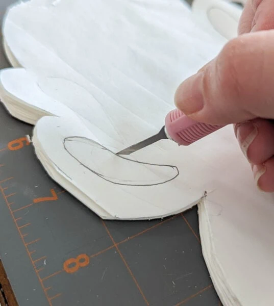 cutting out paper snowflakes with a craft knife.