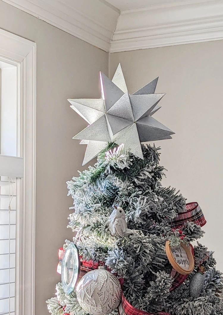 DIY paper Christmas tree star on top of Christmas tree.