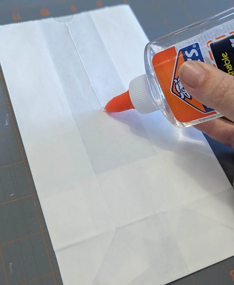 gluing the paper bag with clear school glue.