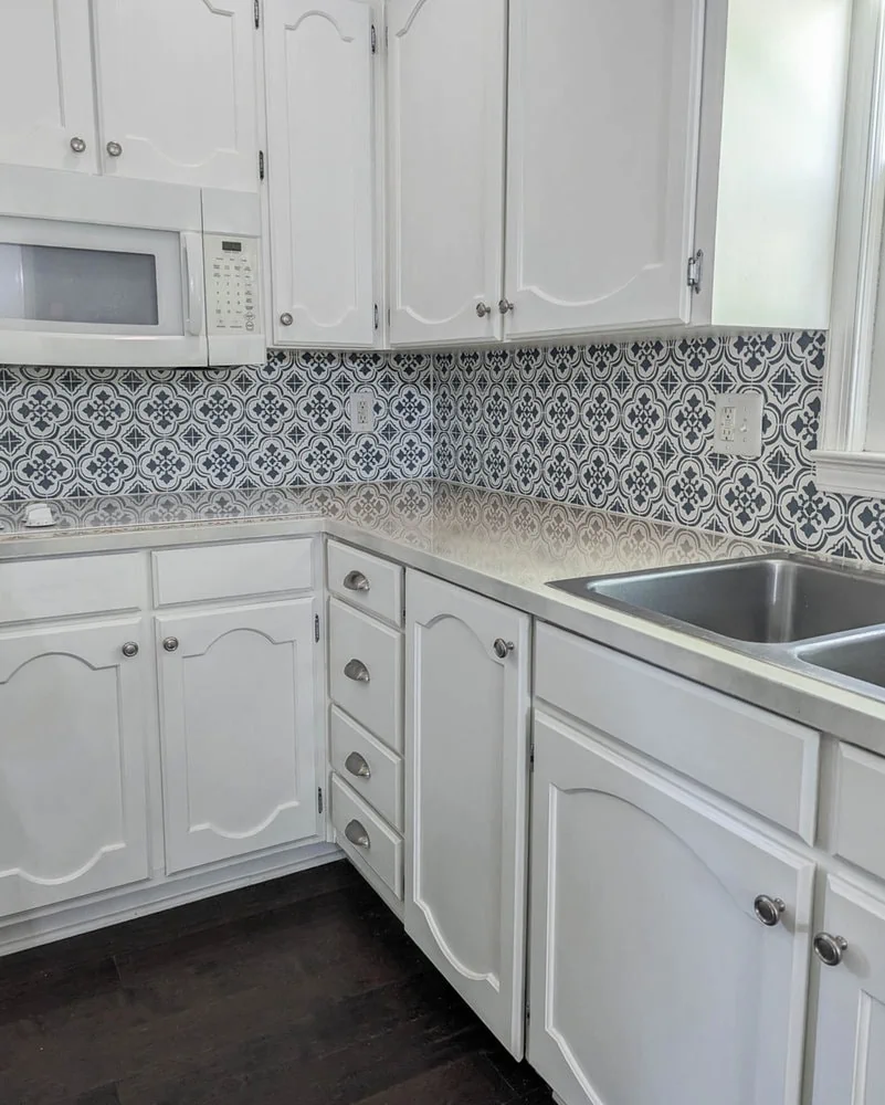 kitchen with white cabinets and painted backsplash.