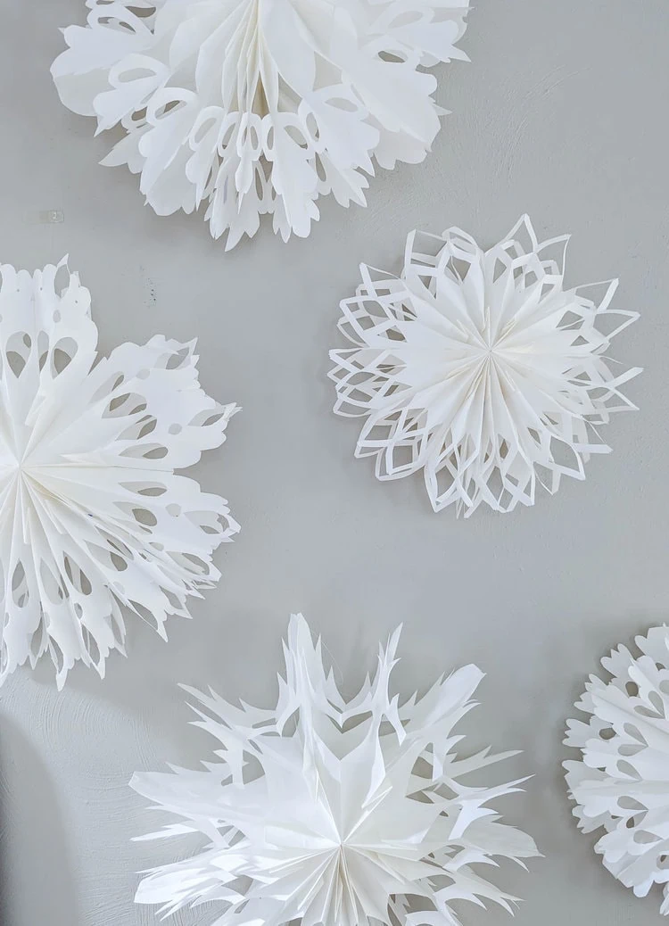 paper bag snowflakes hanging from command hooks on wall.