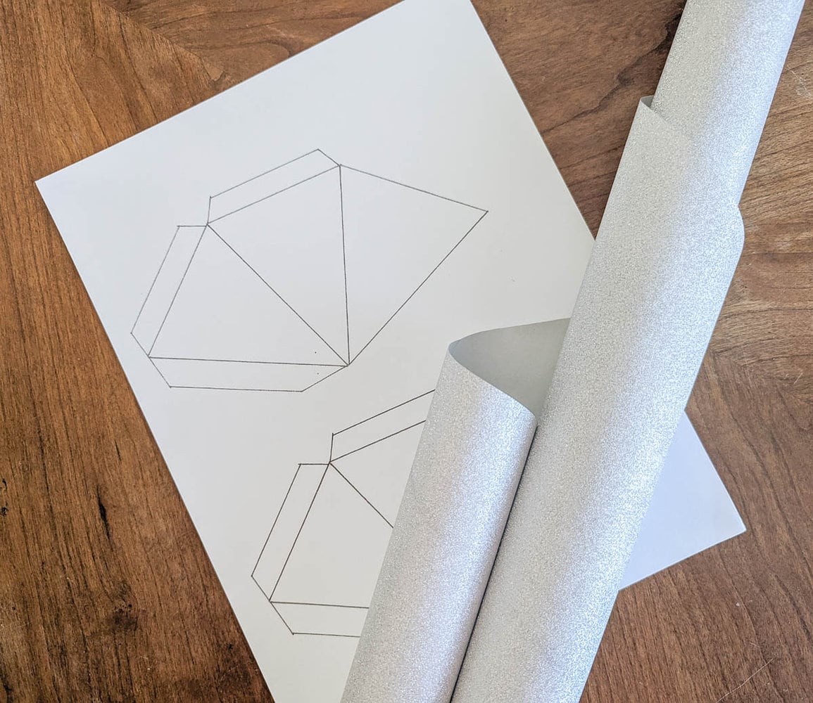 printed star template next to glittery silver wrapping paper.