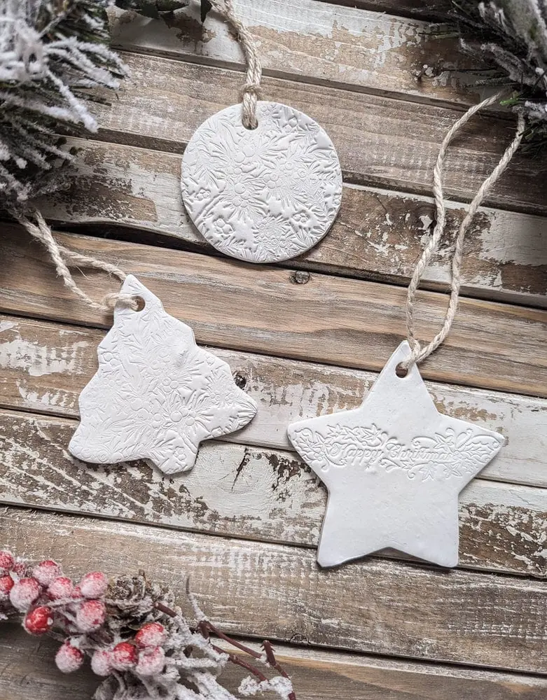 three clay ornaments shaped like a circle, a tree, and a star.