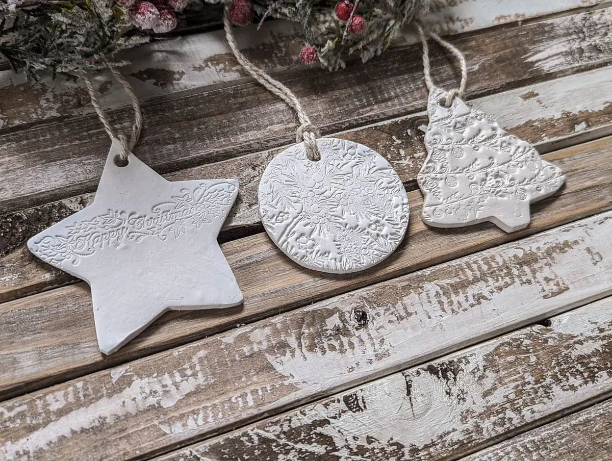 Three white clay ornaments with stamped texture.