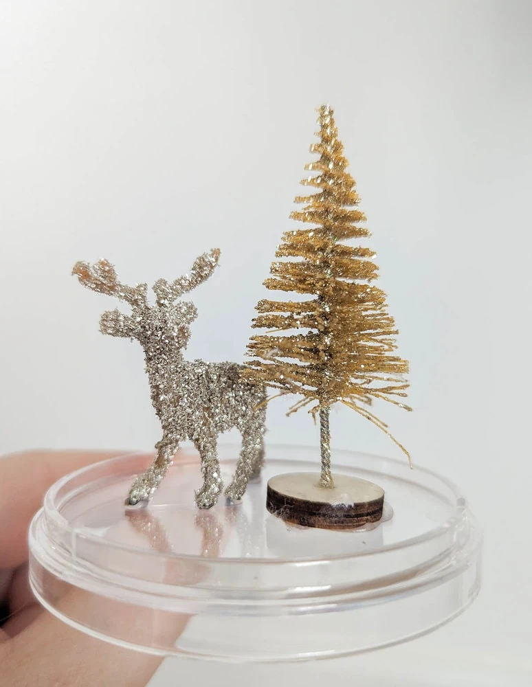 small deer and Christmas tree glued to ornament bottom.