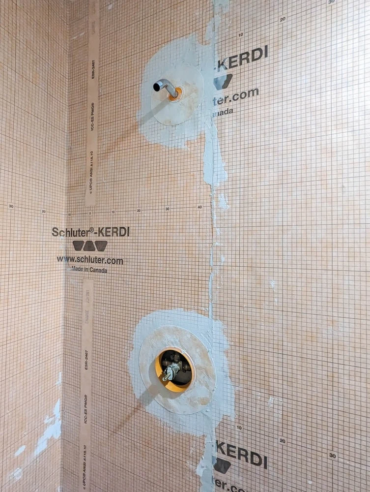 shower pipe and valve surrounded by Kerdi waterproofing material.