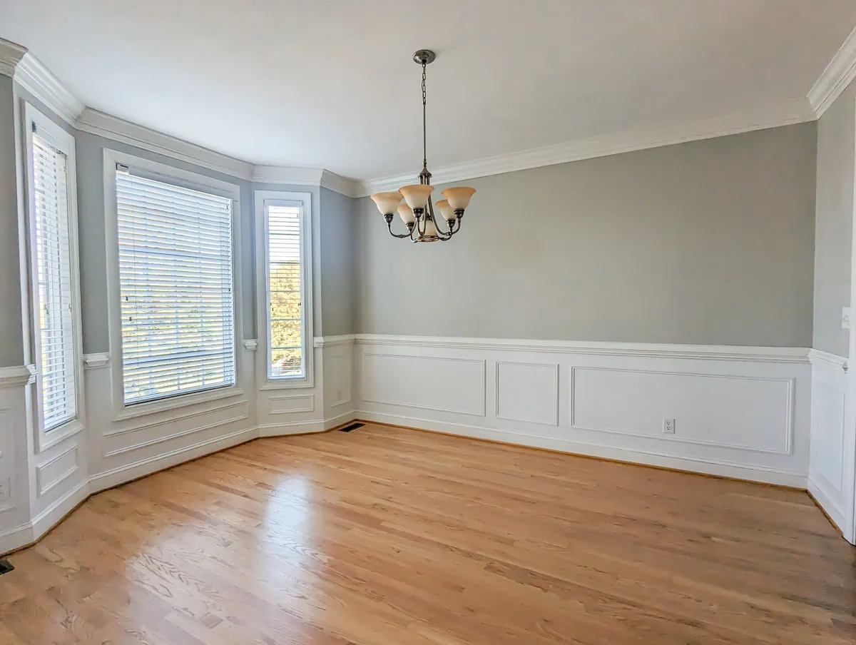 dining room with bay window and wainscotting.