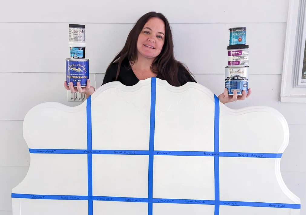 Carrie holding six sealers behind a painted headboard.