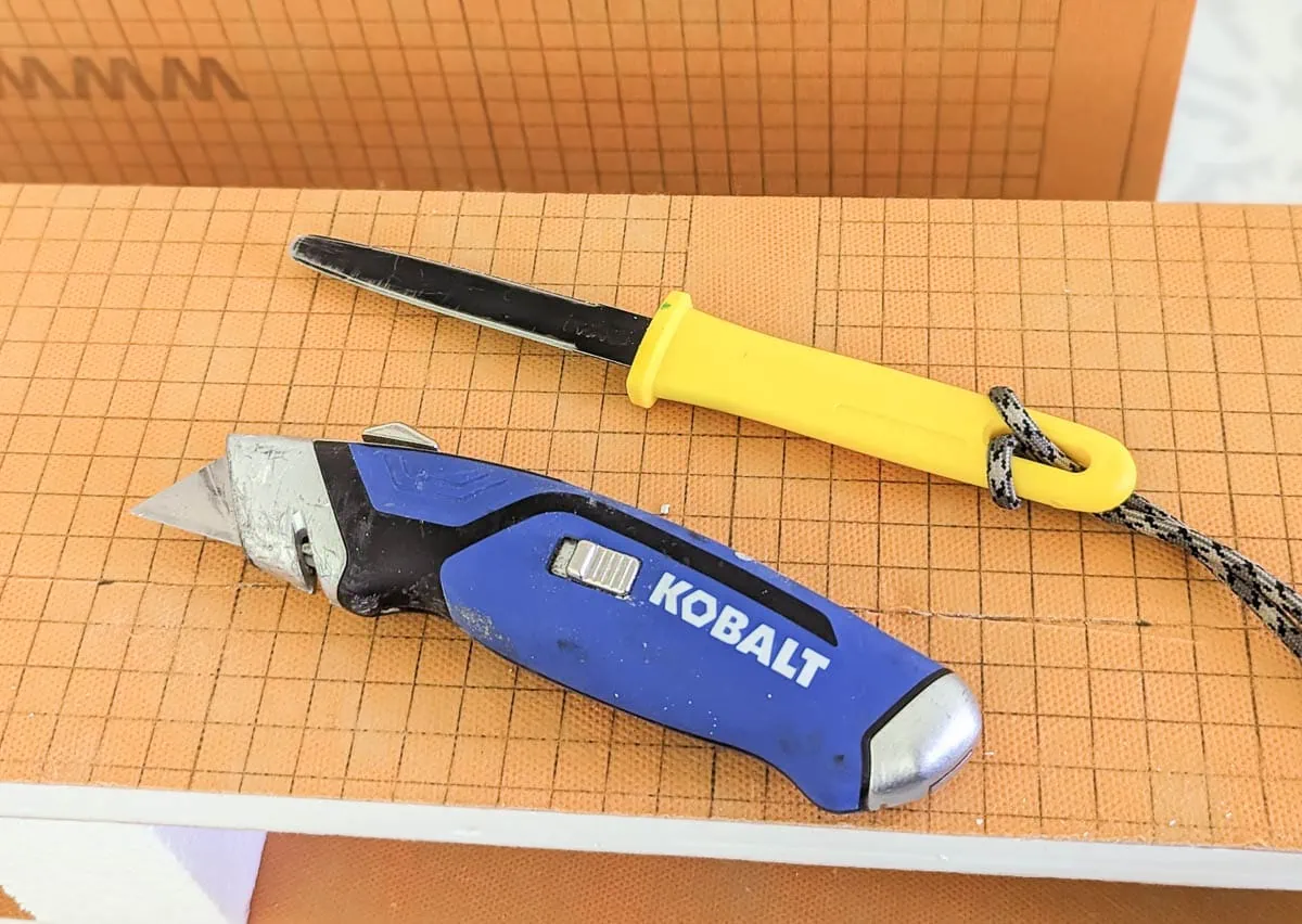 utility knife and cardboard knife of top of foam shower curb.