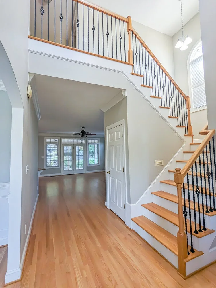 two story foyer with wood floors, looking toward living room.