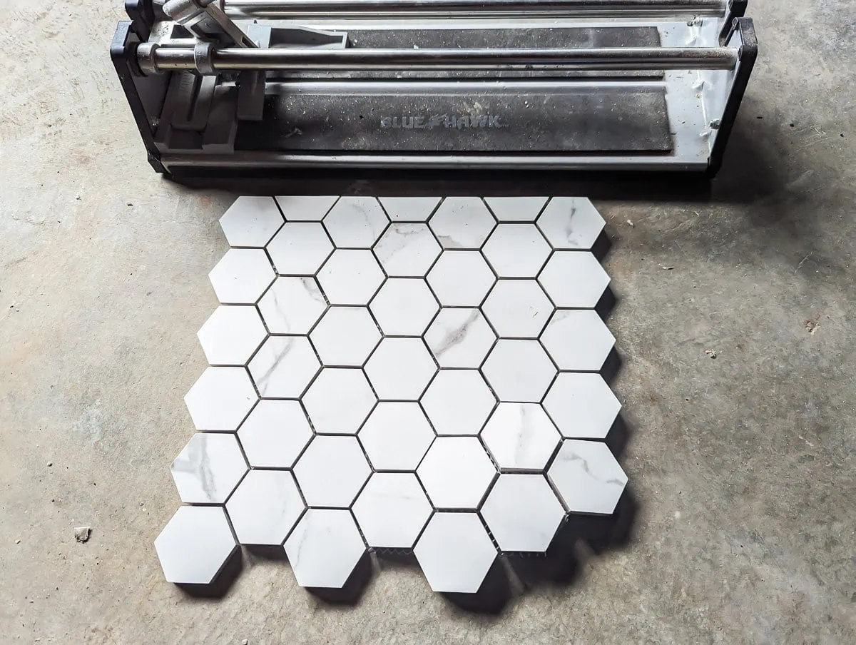 sheet of mosaic tile cut cleanly next to a manual tile cutter.