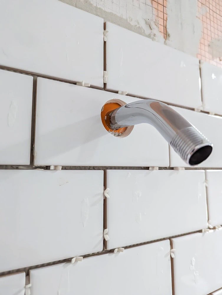 hole cut in tile around shower head using a hole saw.