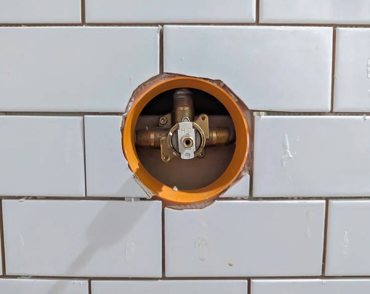 tile around shower valve cut with tile nippers.
