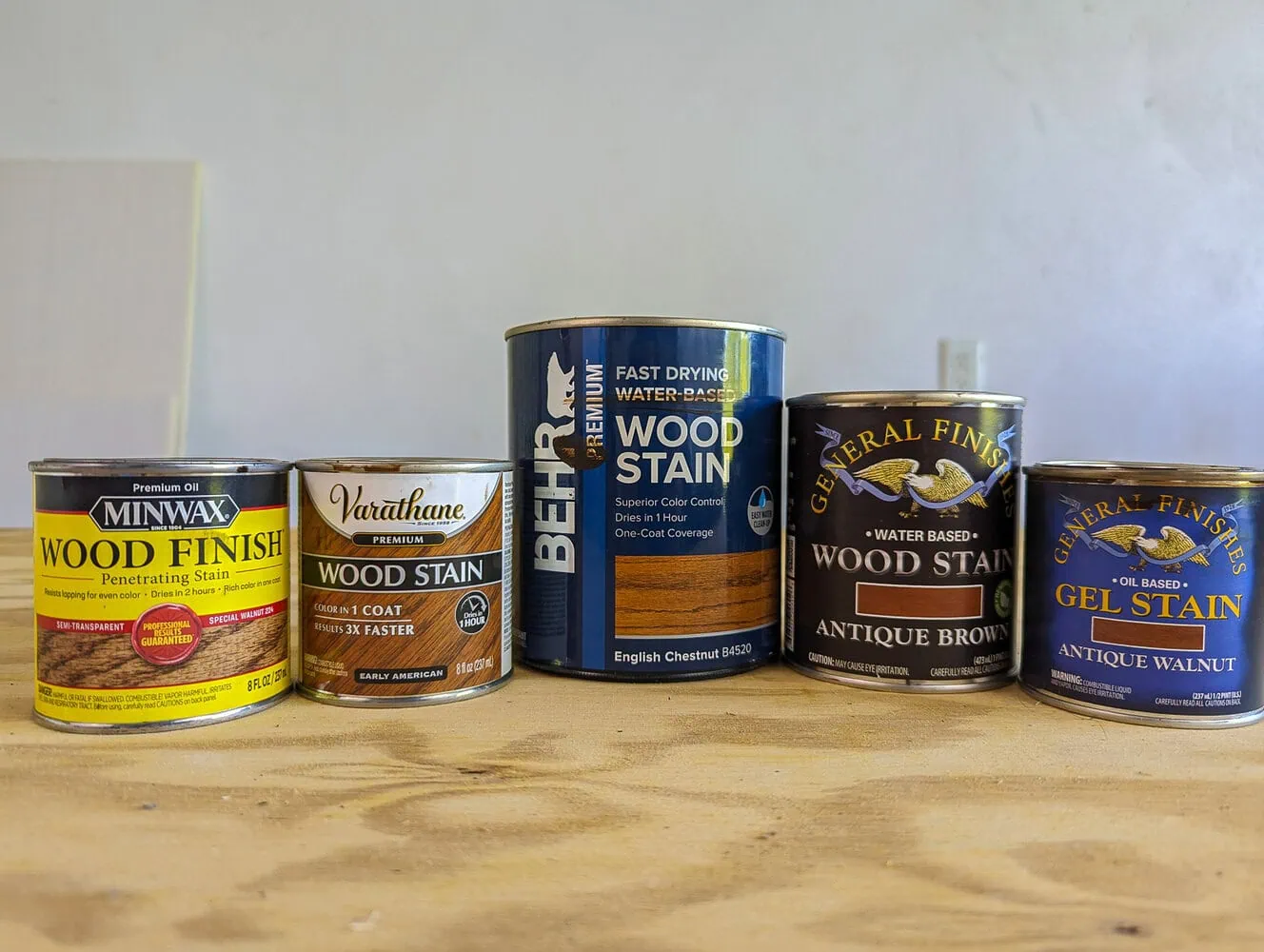 five cans of stain that will be tested on pine.