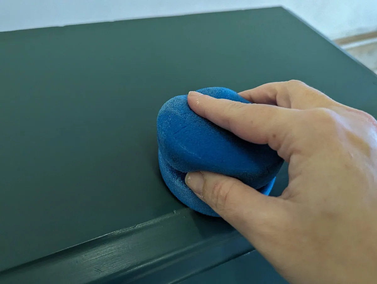 sealing furniture with a blue sponge applicator.