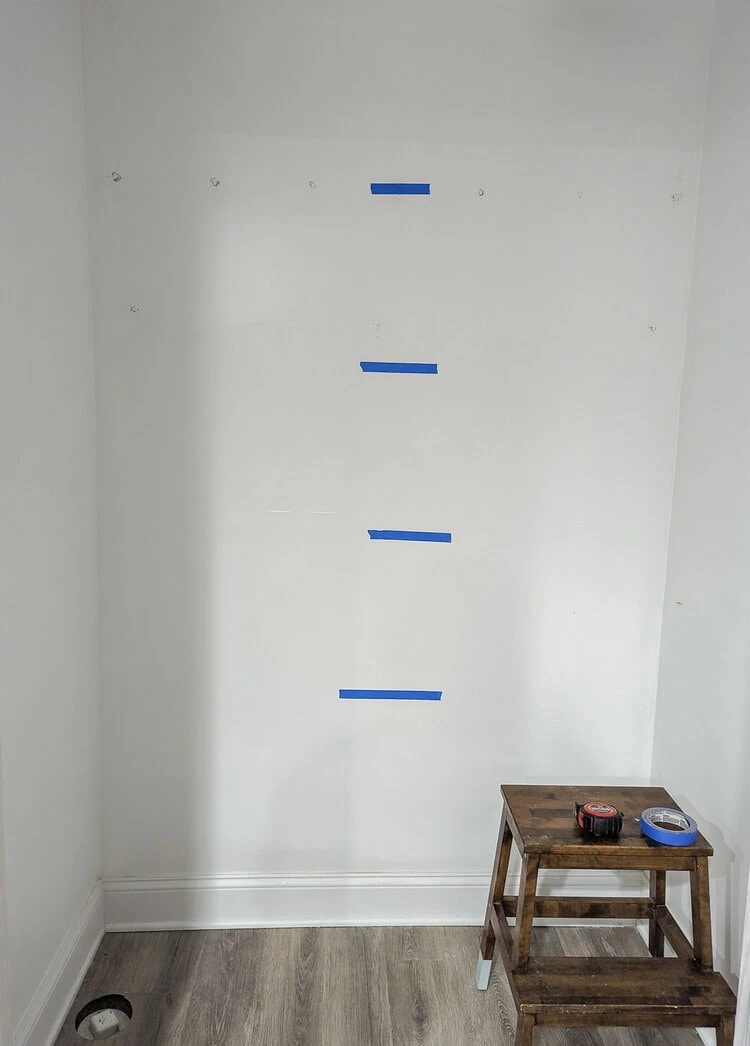 using painter's tape to determine shelf placement.