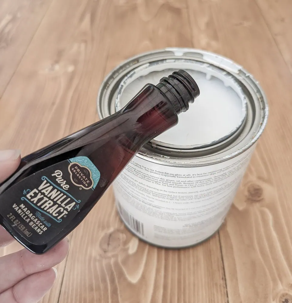 pouring vanilla extract into a can of paint.