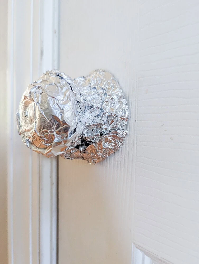 doorknob covered in foil to protect it from paint.