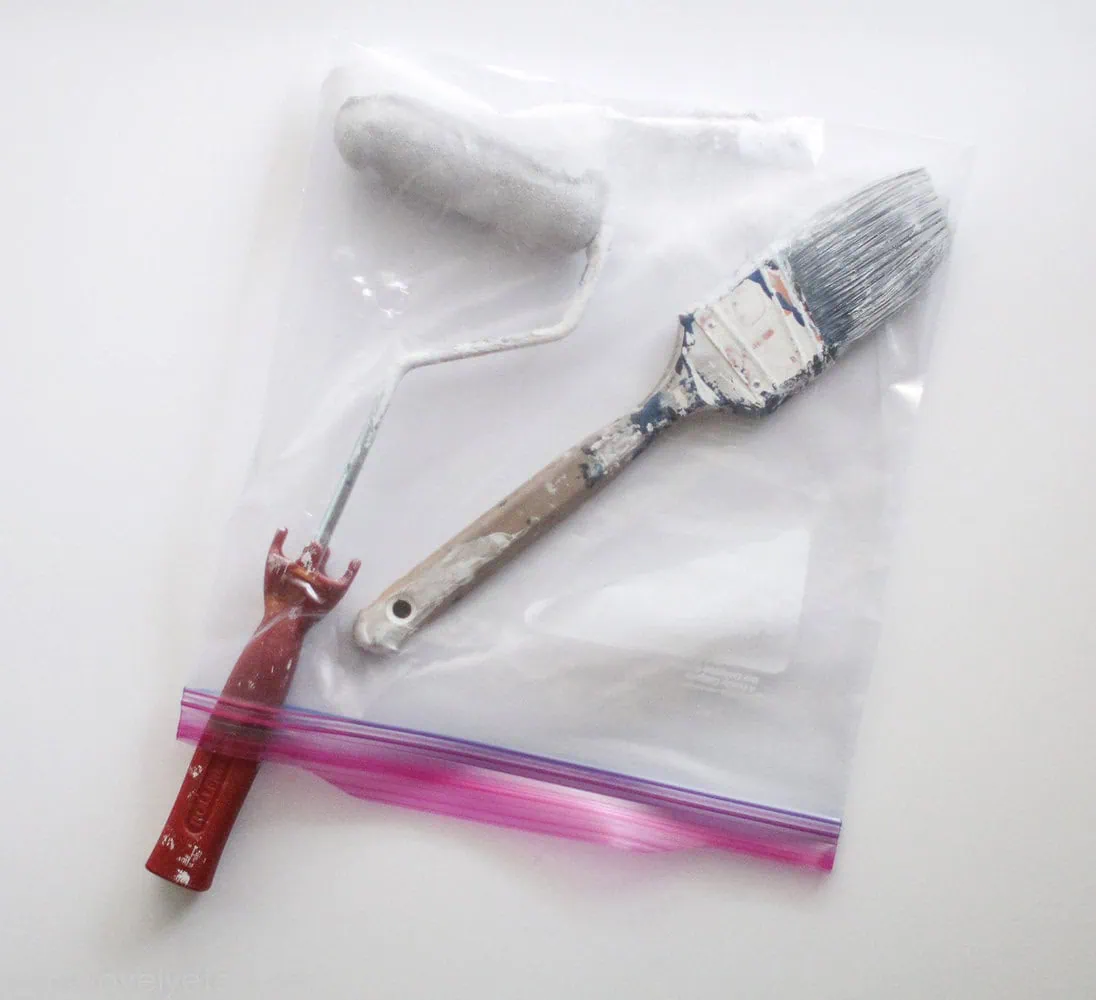 paint brush and paint roller stored in a plastic bag.