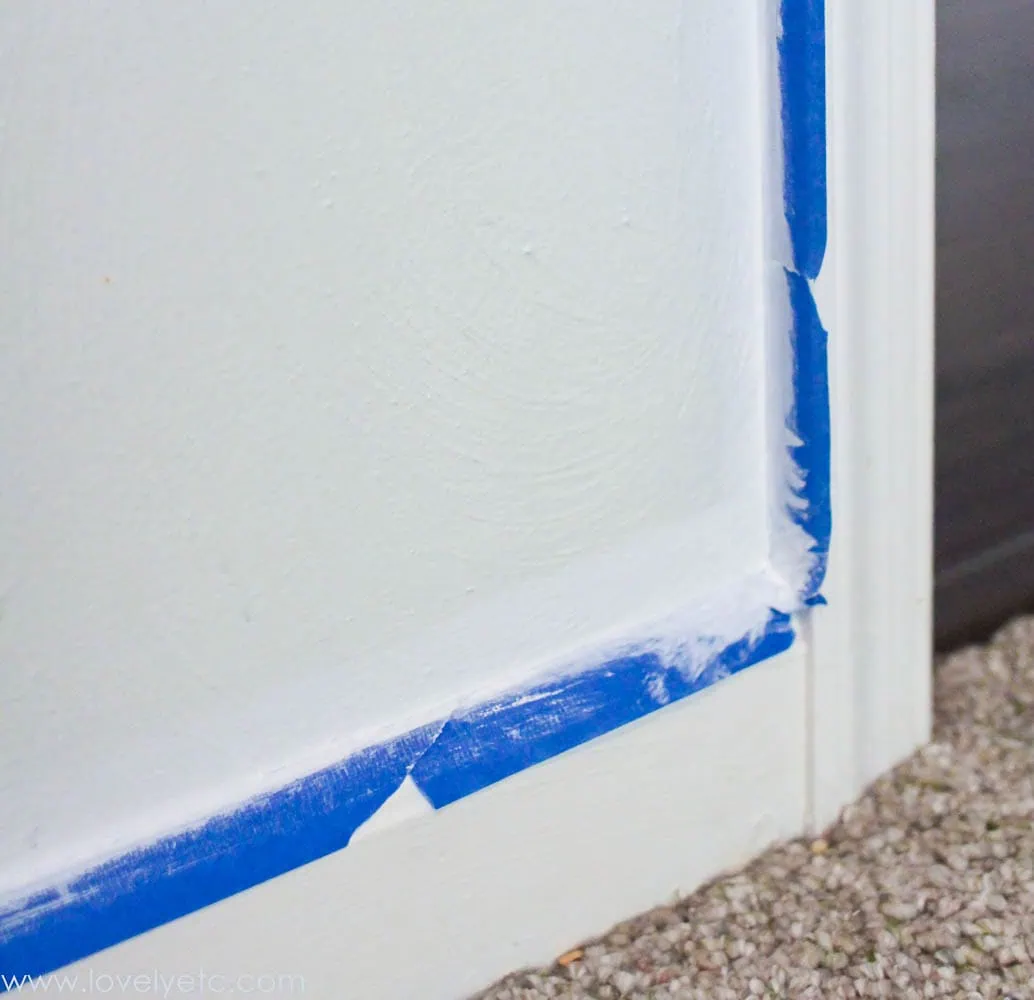 painter's tape on wall with base color painted over it.