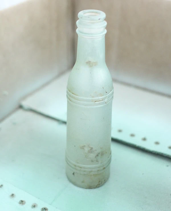bottle in a cardboard box ready to be spray painted.