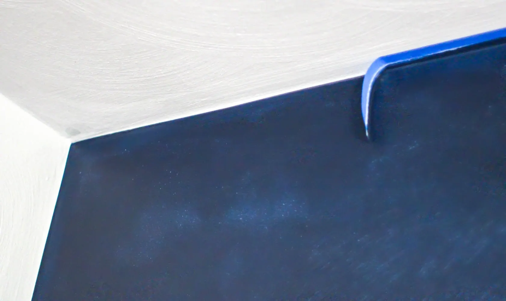 removing painter's tape to reveal a clean paint line.