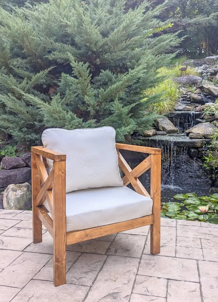 diy wooden outdoor chair with neutral cushions on patio.