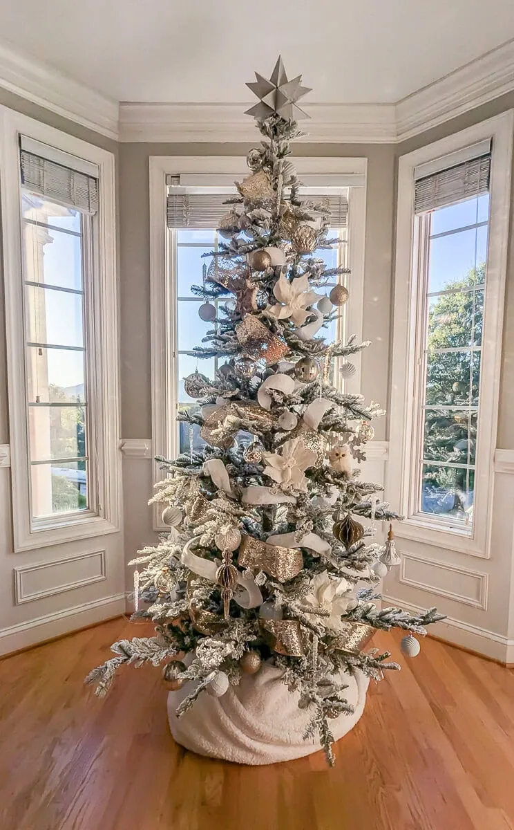 Christmas tree with silver, gold, and white decorations.