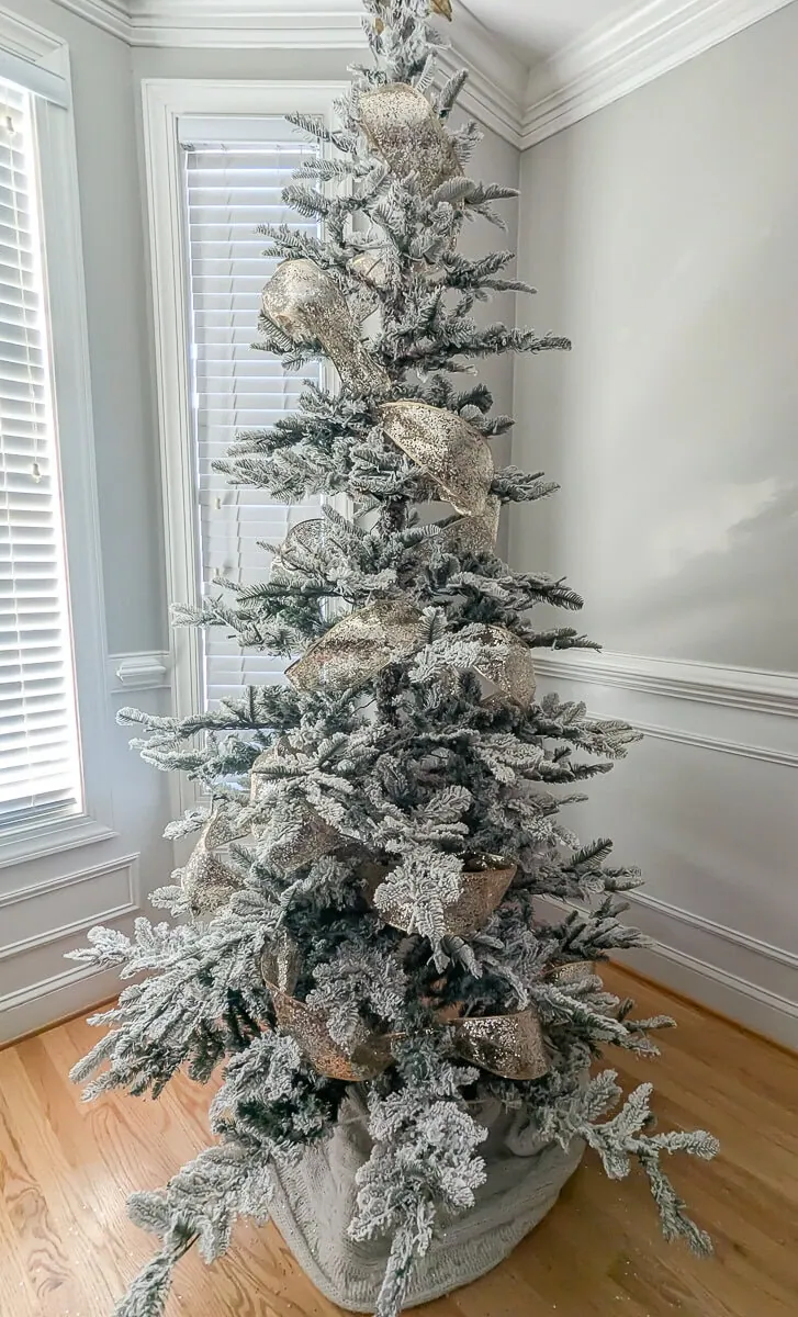 flocked Christmas tree with sparkly gold ribbon.
