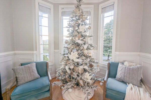 noble fir Christmas tree decorated with silver, gold, and white decorations.