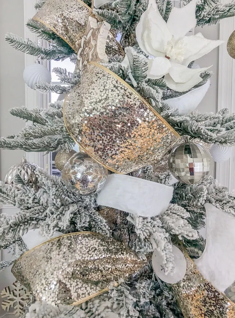 close up of Christmas tree with sparkly gold and white fur ribbon.