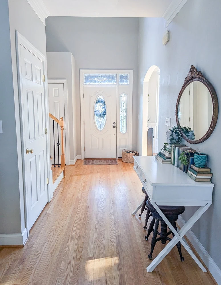 entryway with white front door and wood floors.