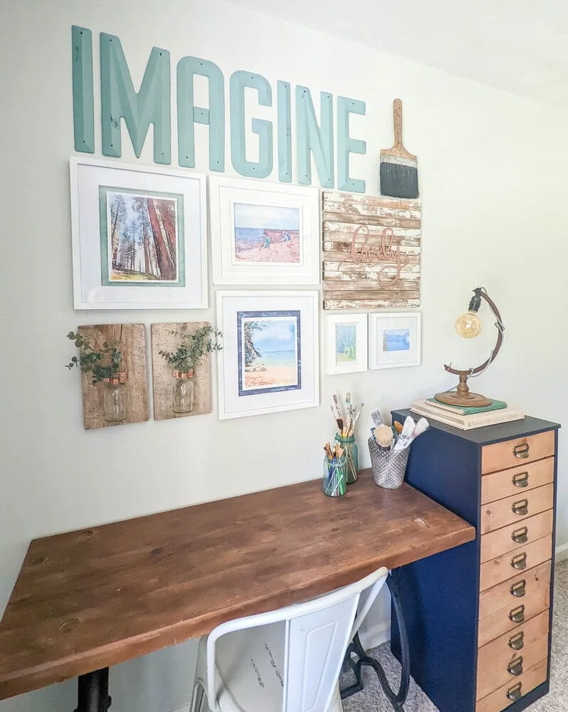 gallery wall above desk with travel photos, wall vases, and vintage letters.