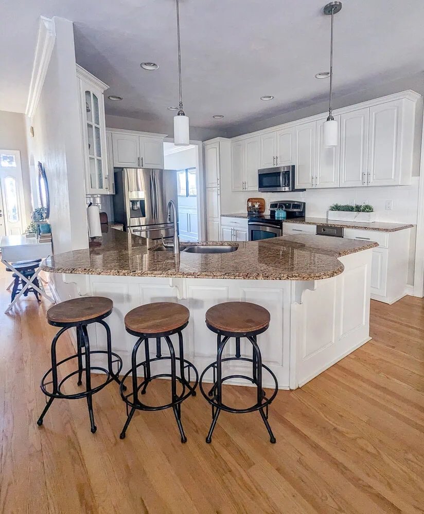 kitchen with white cabinets and brown granite countertops.