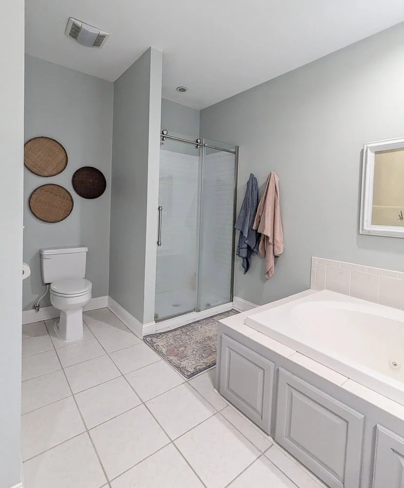 bathroom with blue walls, shower, toilet, and jacuzzi tub.
