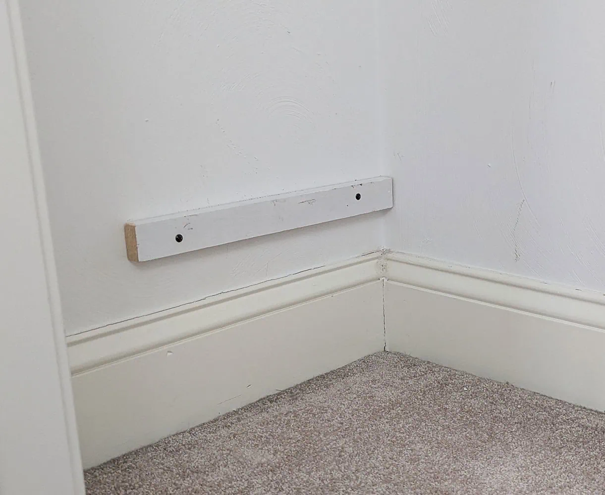 1x2 board screwed to wall to support shelf.