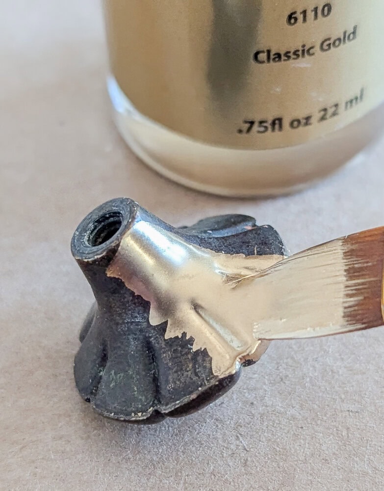 brushing liquid leaf onto the hardware.
