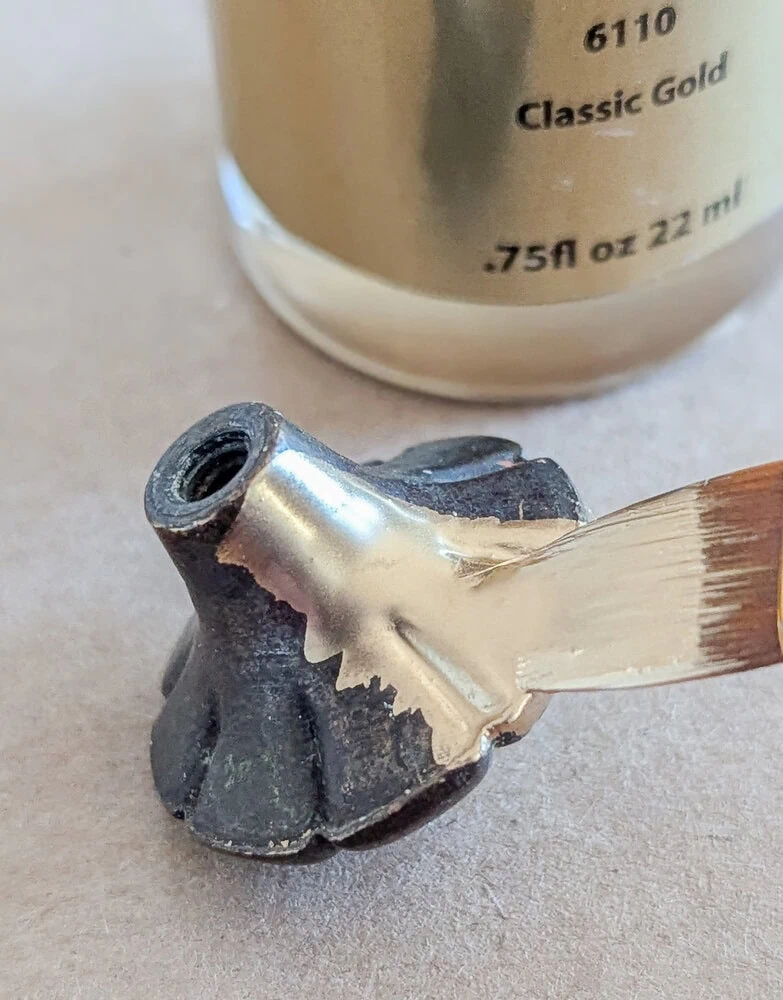 brushing liquid leaf onto the hardware.